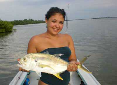 woman in bathing suit on a boat holding a cravelle jack fish catch