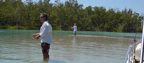 two men fishing in mangroves standing in the water